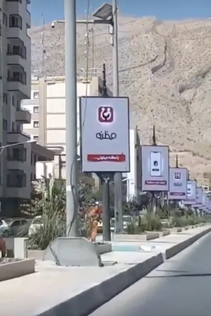 Cropped source screenshot of repeated Mazzaneh brand billboards along a city road
